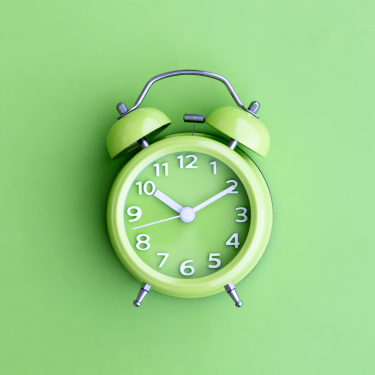 Lime green alarm clock on a lime green background