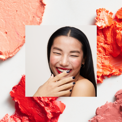 Girl laughing with orange makeup swatches in background