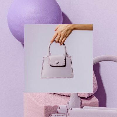 Small lavender leather satchel held over a lavender abstract background