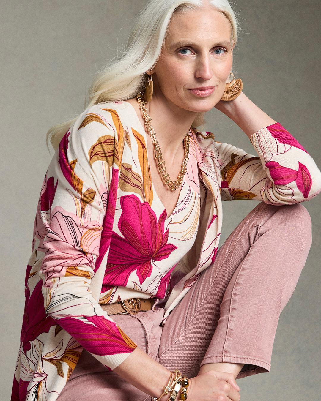 a model posing in a floral shirt and pink pants